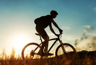 rowerzysta na tle zachodzącego słońca 